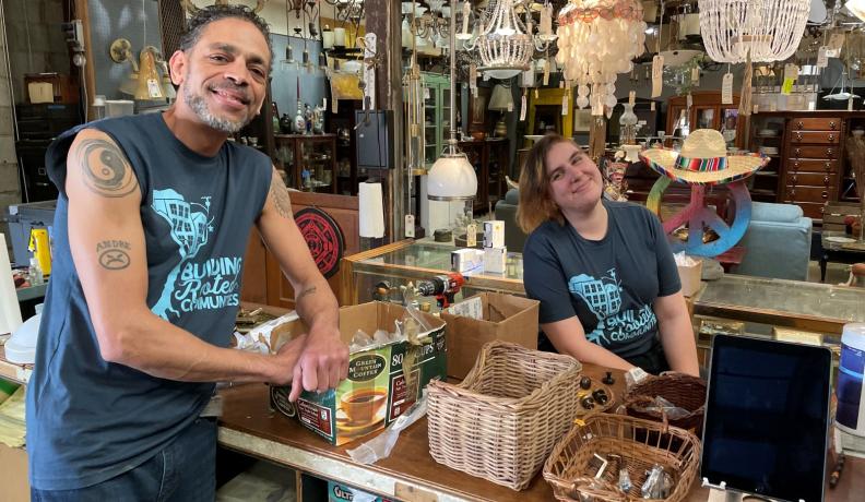 Two Community Forklift employees standing at the register and smiling at the camera.