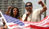 Image: two people at rally, with American flag in foreground. Topic: A Discussion Guide for Climate Justice