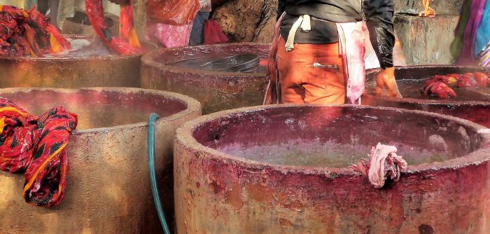 Image: workers dyeing textiles in large concrete vats. Topic: Toxic Textiles