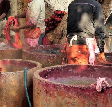 Image: workers dyeing textiles in large concrete vats. Topic: Toxic Textiles