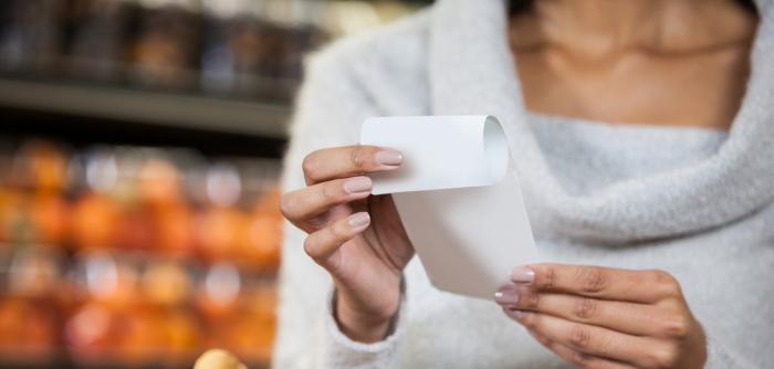Image: woman holding paper receipt Topic: Skip the Slip to reduce store receipts