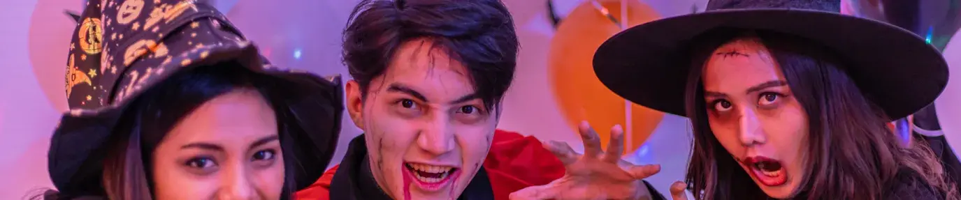 Three young Asian people dressed up for Halloween at a party. Sustainable Halloween Costumes.