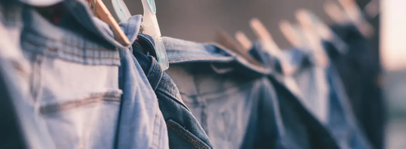 Image: Jeans hanging on a clothesline. Topic: sweatshop-free clothing.