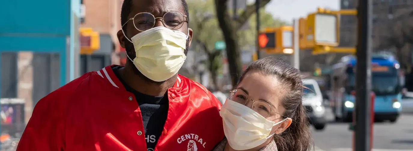 couple poses on the street with masks