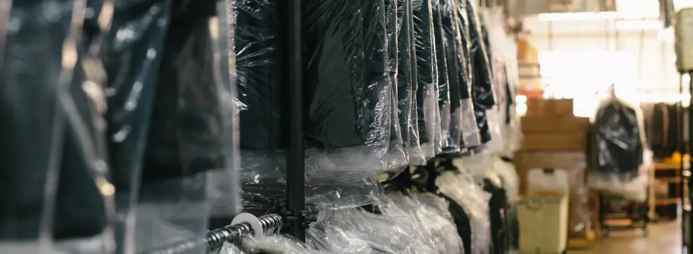 Image: suit rack at dry cleaners. Topic: Green Dry Cleaning
