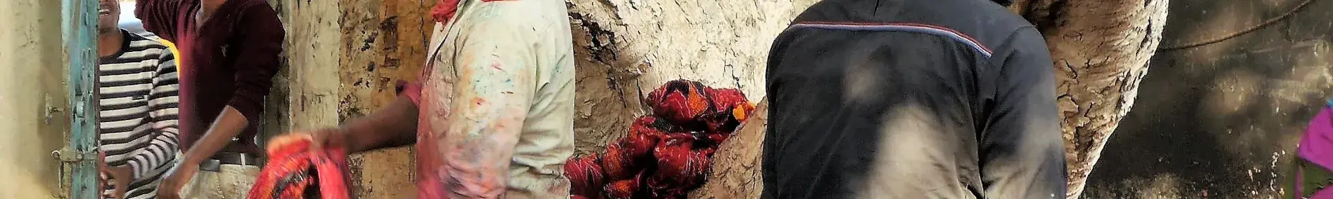 Image: workers dyeing textiles in large concrete vats. Topic: Toxic Textiles