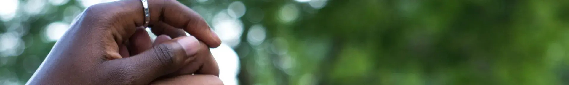 Image: hands held and thrust into the air. Topic: Green America's Work on Social Justice.